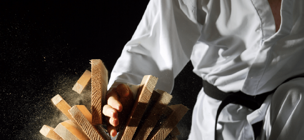 Man karate chopping blocks of wood