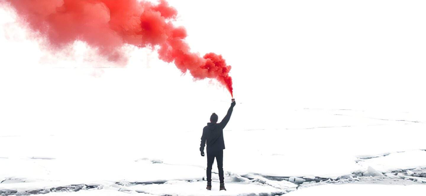 A man standing with a red flare