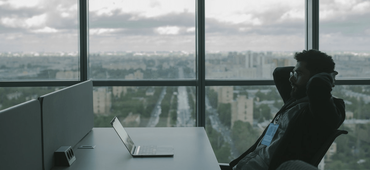 Man sitting at a desk with laptop in a high rise building