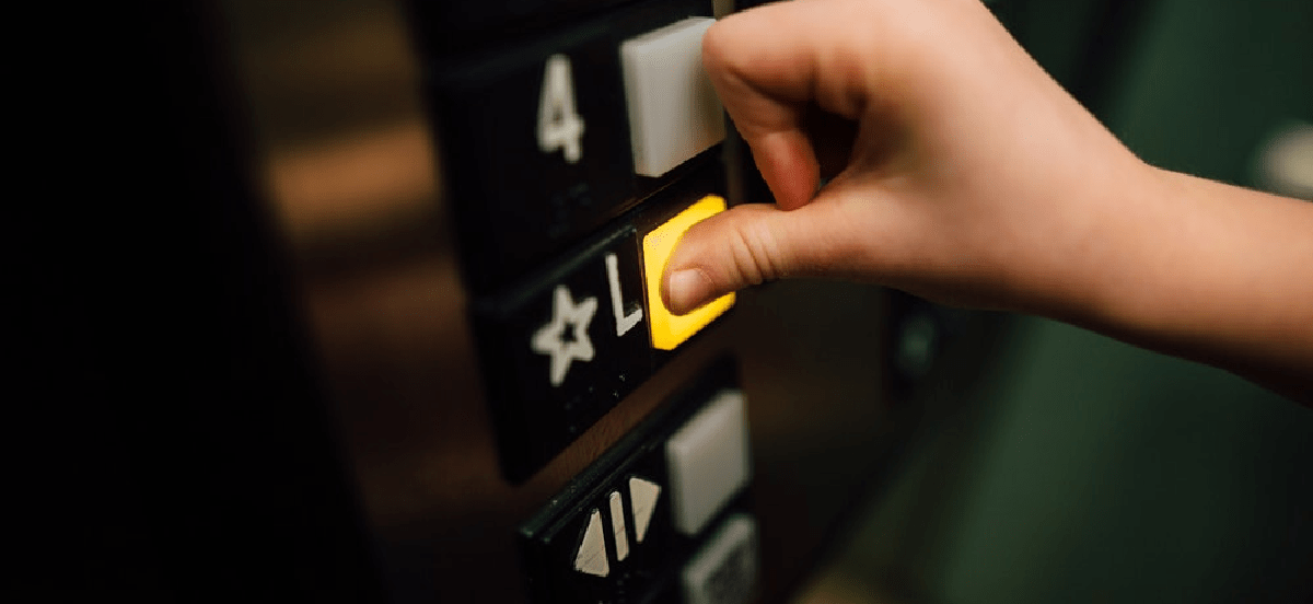 Person pressing a floor button in a lift