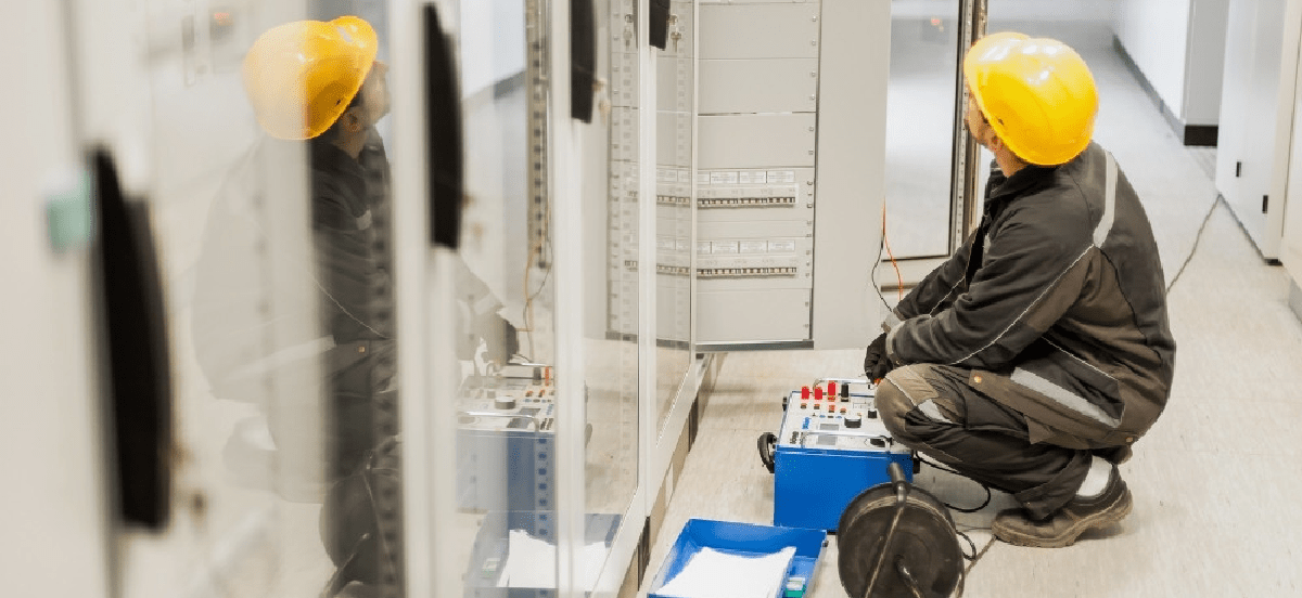 Engineer with a yellow hard hat working in a server room