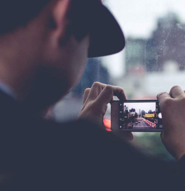 Man taking photo on mobile phone.