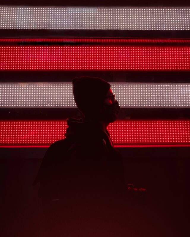 Silhouette of an anonymous hacker in red lighting
