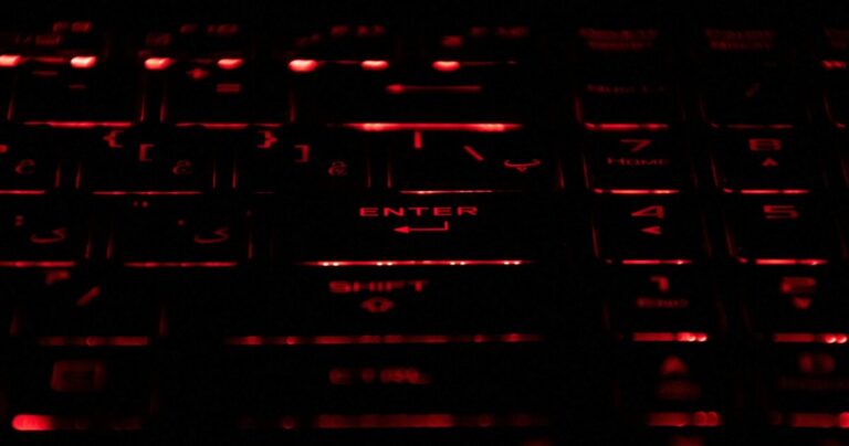 Close-up of a mechanical keyboard with red-lit keys, symbolizing offensive cybersecurity activity.