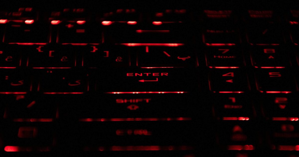 Close-up of a mechanical keyboard with red-lit keys, symbolizing offensive cybersecurity activity.