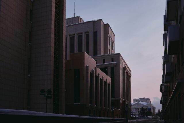 Low-angle view of institutional buildings at dusk, symbolising structure and resilience in a regulated environment