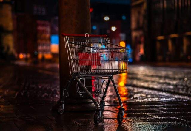 Shopping cart left on a wet city street at night, symbolising online shopping risks during Prime Day