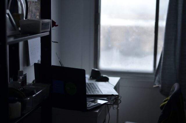 Dimly lit computer in a dark room, evoking hidden threats and reduced visibility.