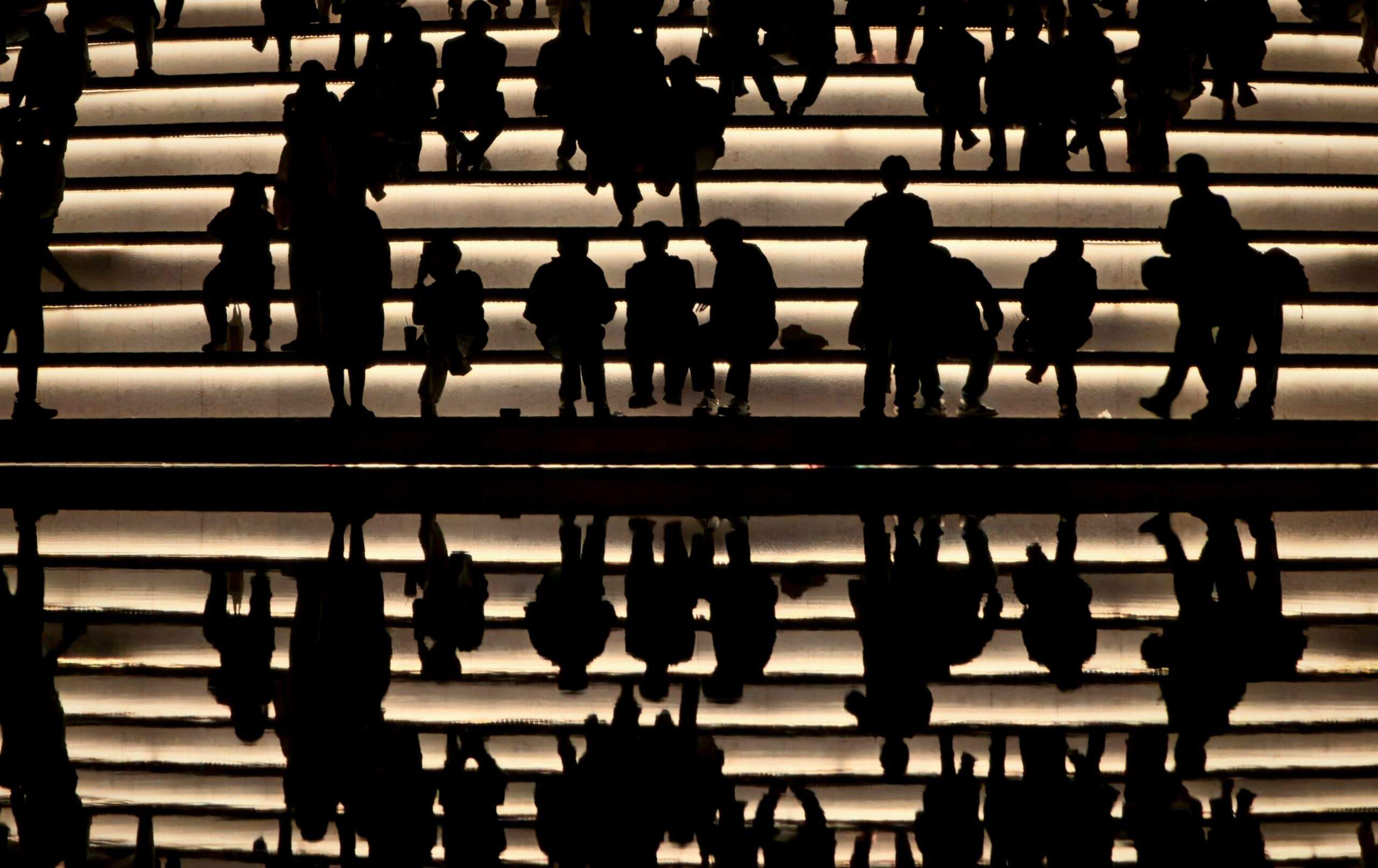 Silhouettes of a team standing together in low light, representing collaboration within a Security Operations Center.