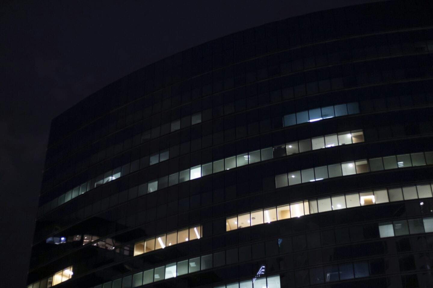 Modern office building at night showing AI agent security risks with autonomous systems running in corporate networks