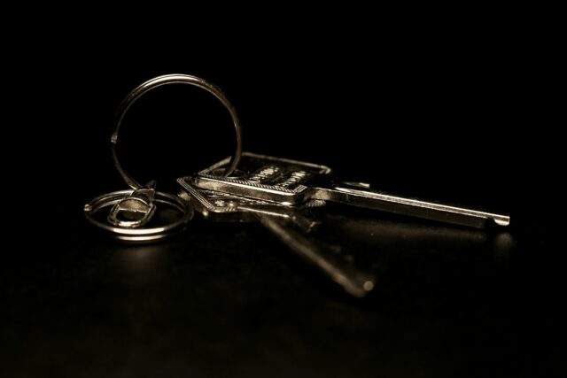 A set of keys hanging alone in a dimly lit space, symbolising unprotected admin access left exposed in source code