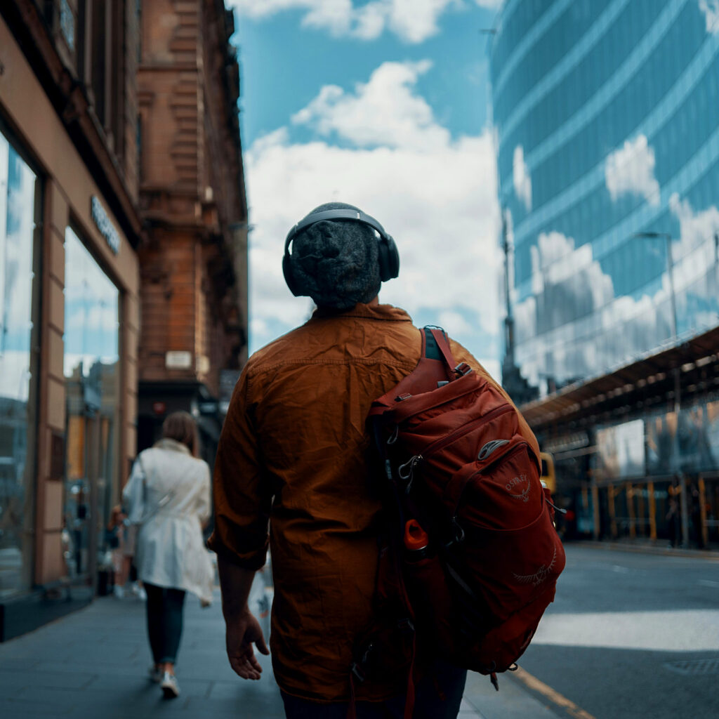 A man walking away from the camera down a street