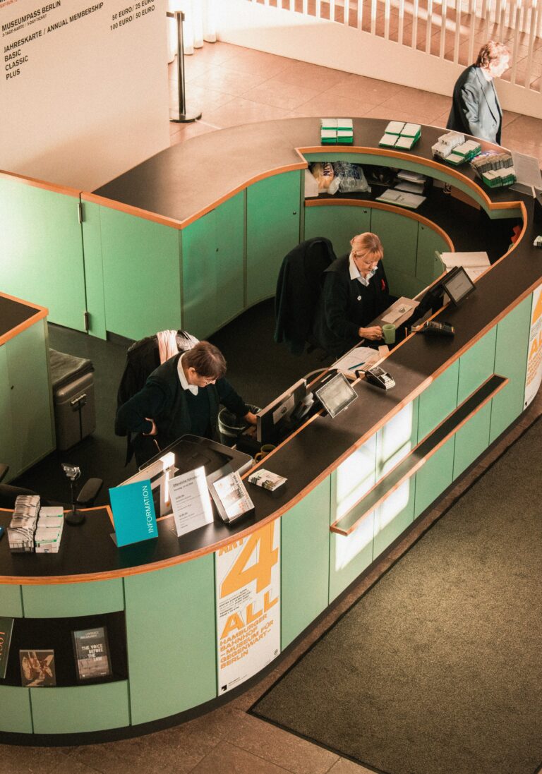 Two people sitting at a reception desk.
