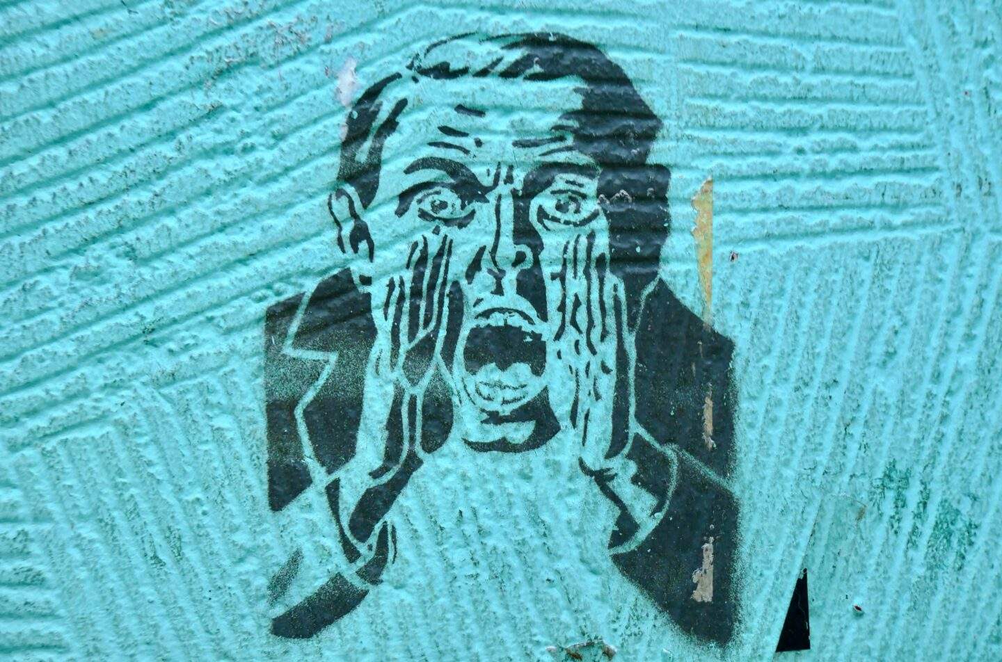 Alt text "Stencil street art of a man in a suit, one hand pressed to his face, mouth open mid-scream, on a teal wall — symbolizing loss of control and panic in the face of a security breach.