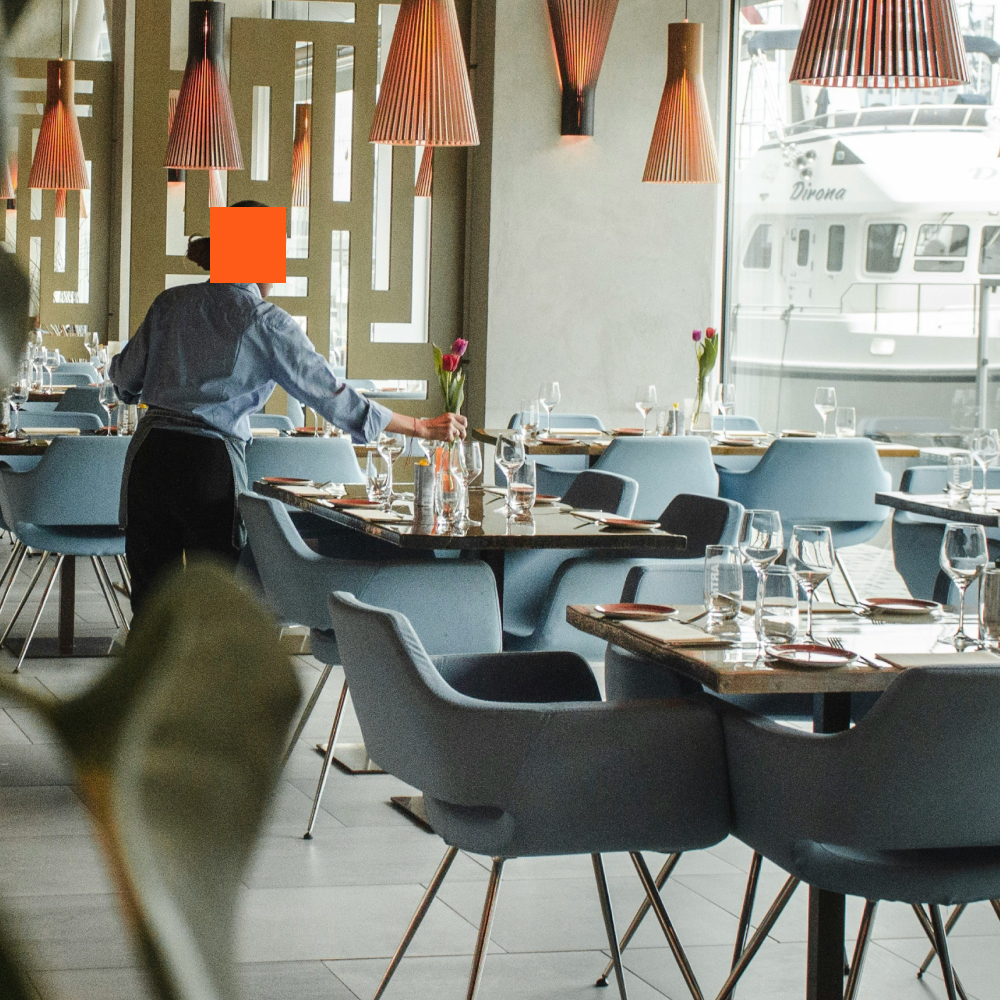 Waiter setting a table in an otherwise empty restaurant