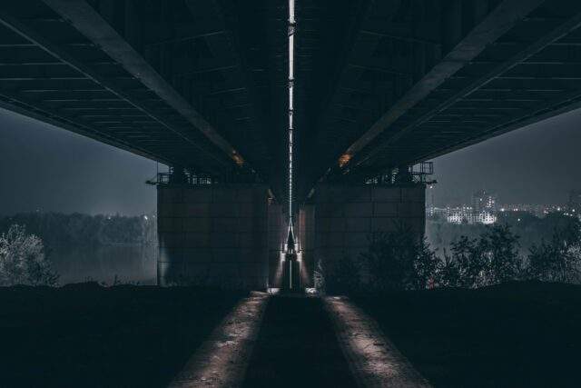 Two dimly lit paths diverging into darkness, representing the choice between a minimum viable DORA testing program and a genuinely resilient one.