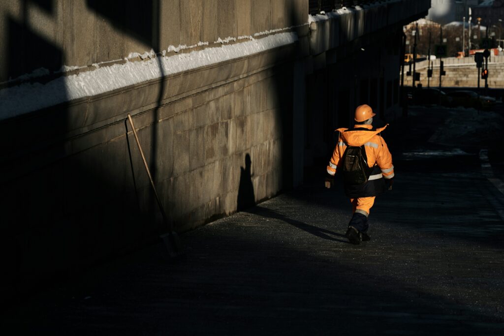 A person in a high-vis jacket walking through a tube station, evoking the ordinary, unquestioned presence a tailgating attack relies on to bypass physical securit