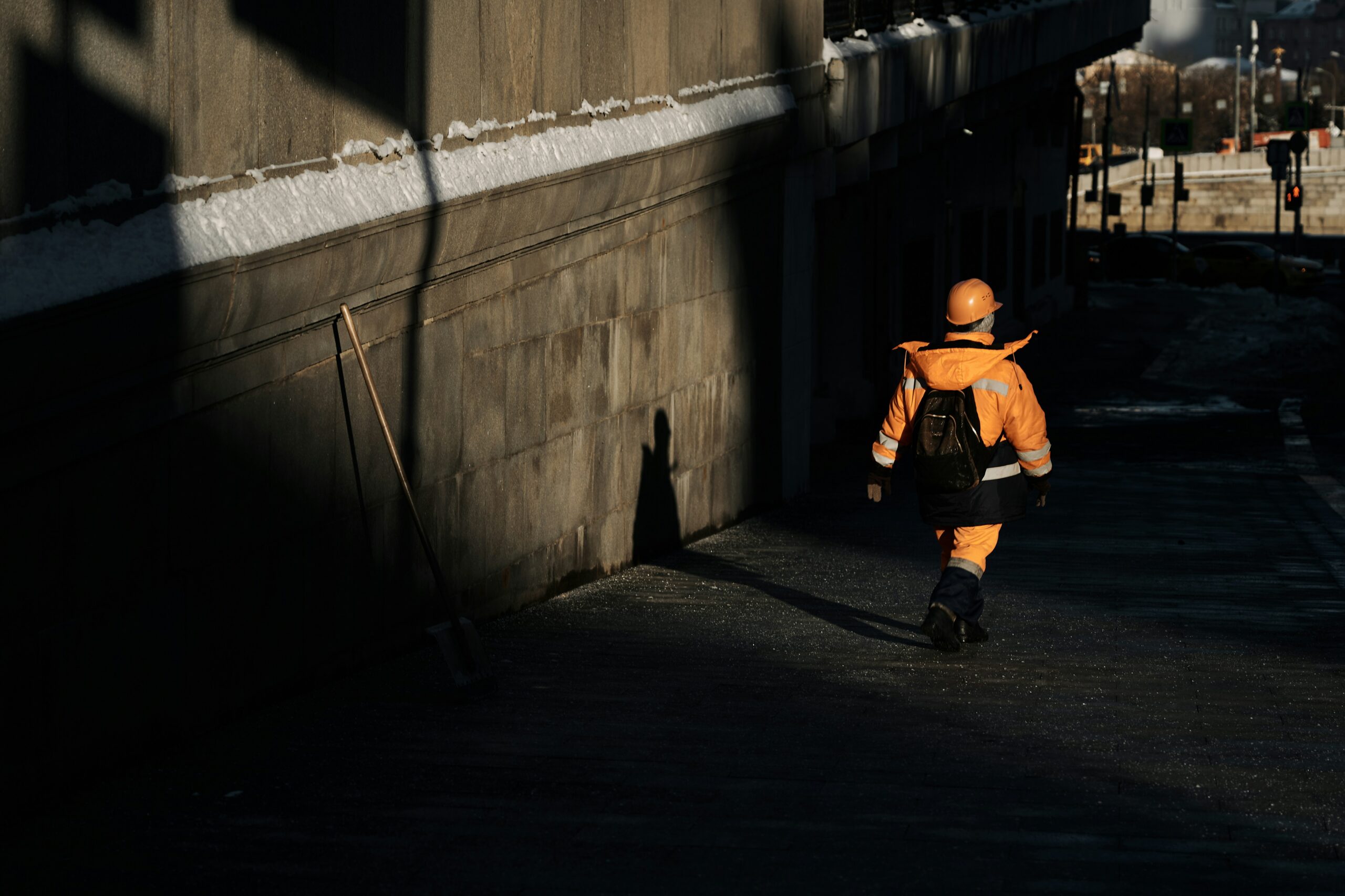 A person in a high-vis jacket walking through a tube station, evoking the ordinary, unquestioned presence a tailgating attack relies on to bypass physical security