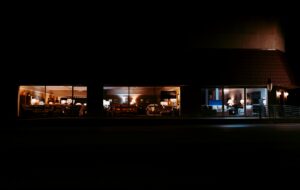 A furniture showroom lit up at night behind glass, empty and unattended, evoking a demo environment that gets none of the scrutiny given to production.