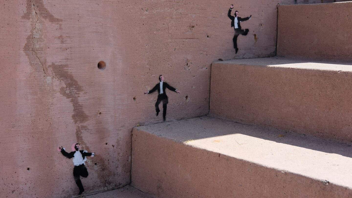 Stencilled figures scatter down a concrete stairwell, several breaking away from formation, symbolising AI agents moving outside their intended scope.