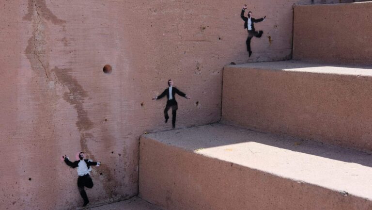Stencilled figures scatter down a concrete stairwell, several breaking away from formation, symbolising AI agents moving outside their intended scope.