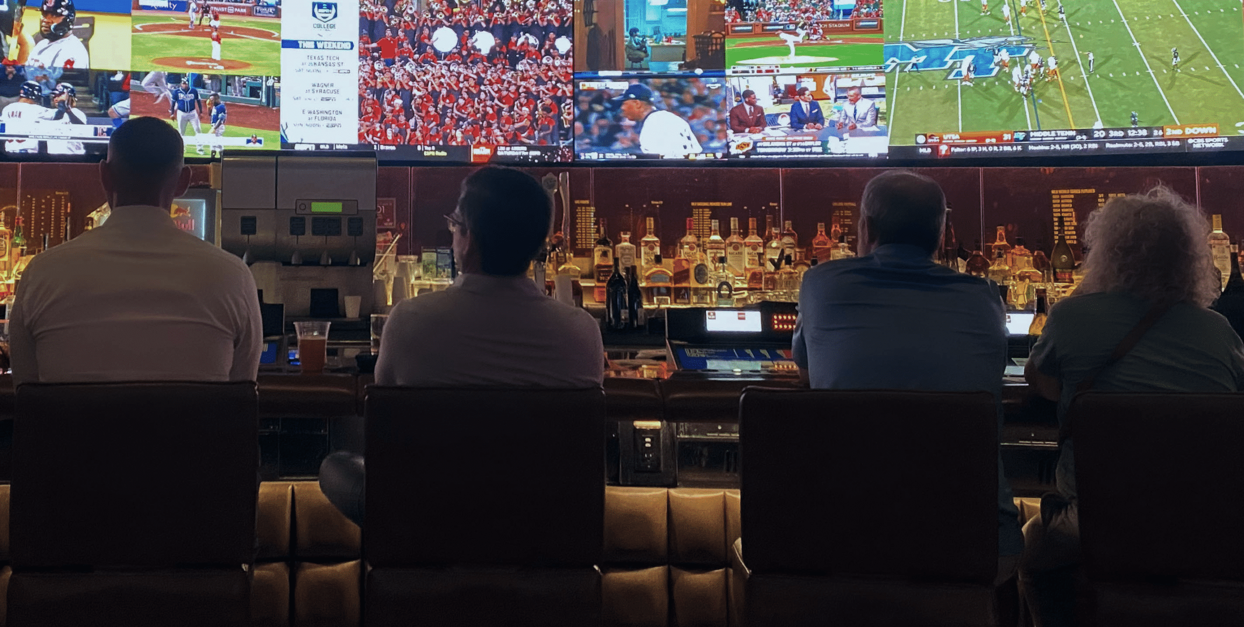 A row of people watching TV screens