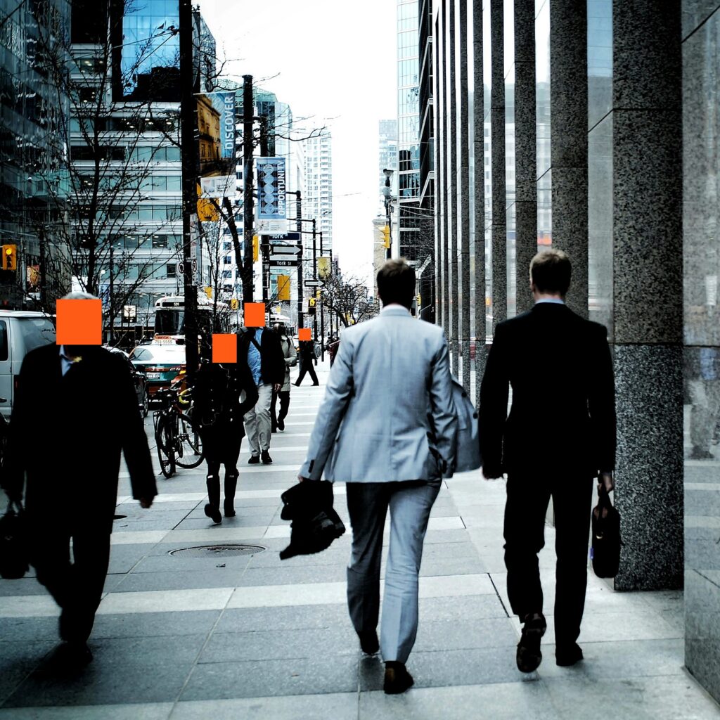 Commuters walking along a busy city sidewalk